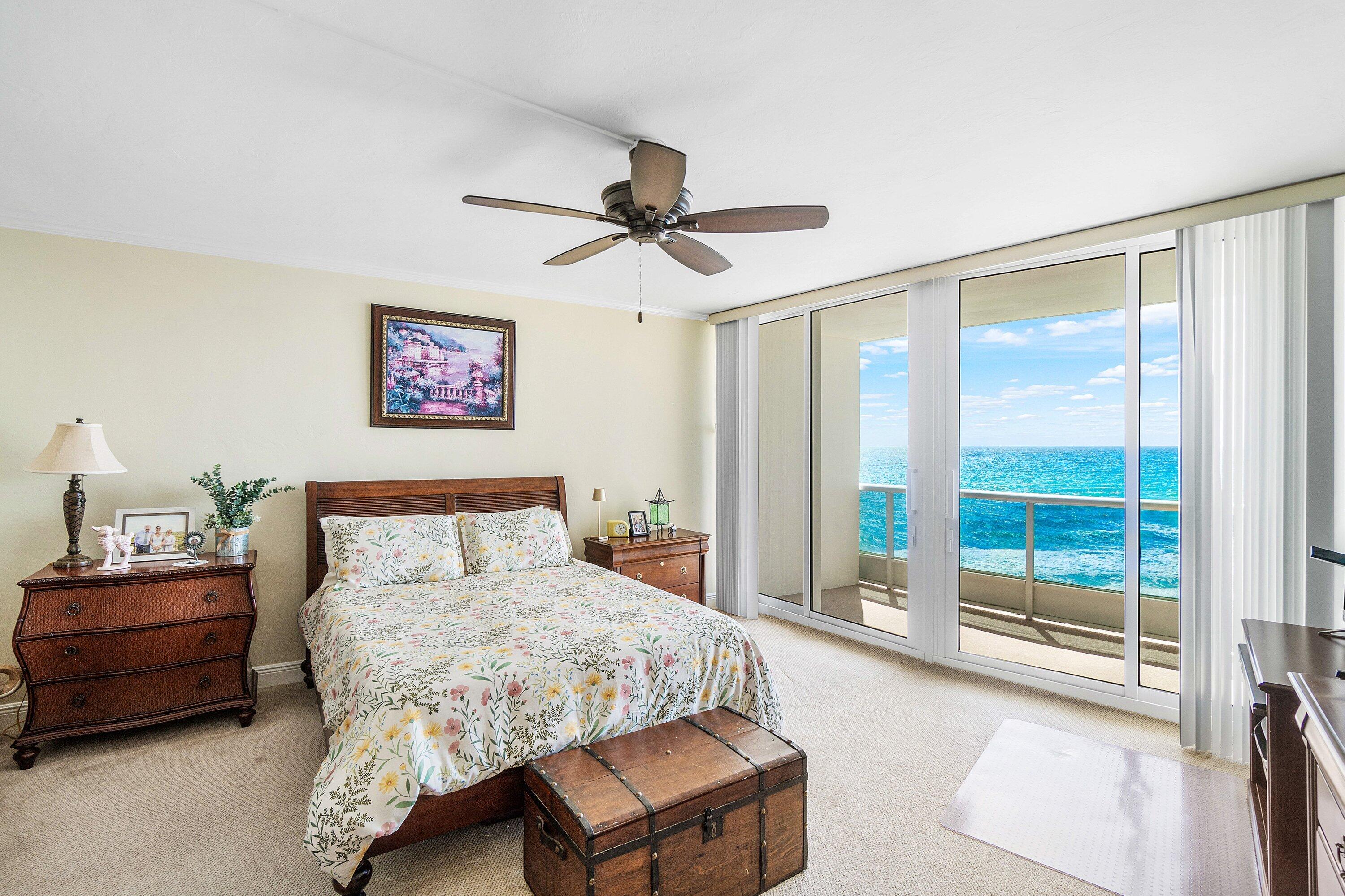 700 South Ocean Boulevard, Unit 804 Boca Raton, FL 33432 - Photo 17 of 39 a bedroom with a bed a chandelier and a dresser