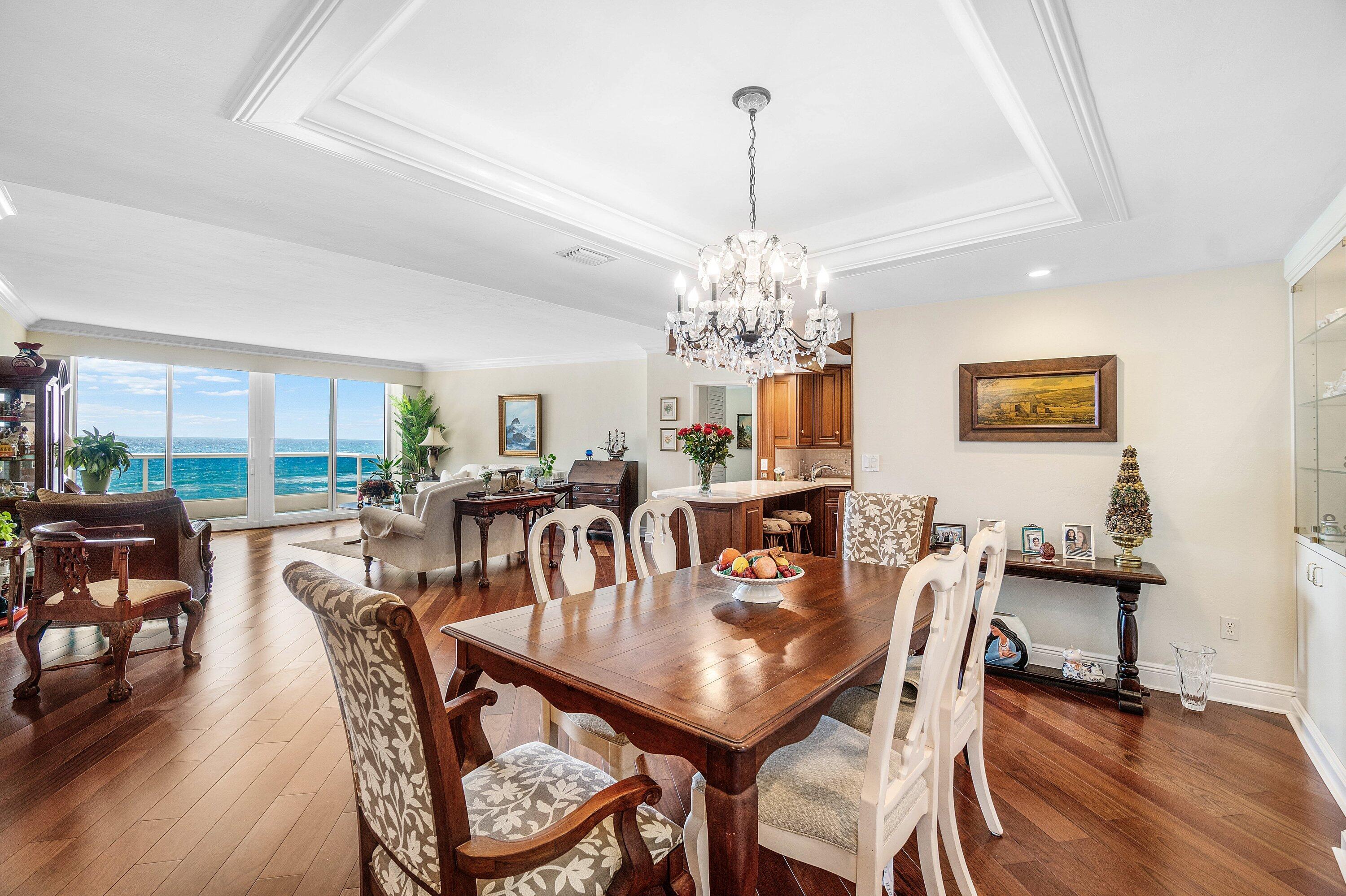 700 South Ocean Boulevard, Unit 804 Boca Raton, FL 33432 - Photo 8 of 39 a view of a dining room with furniture wooden floor and chandelier