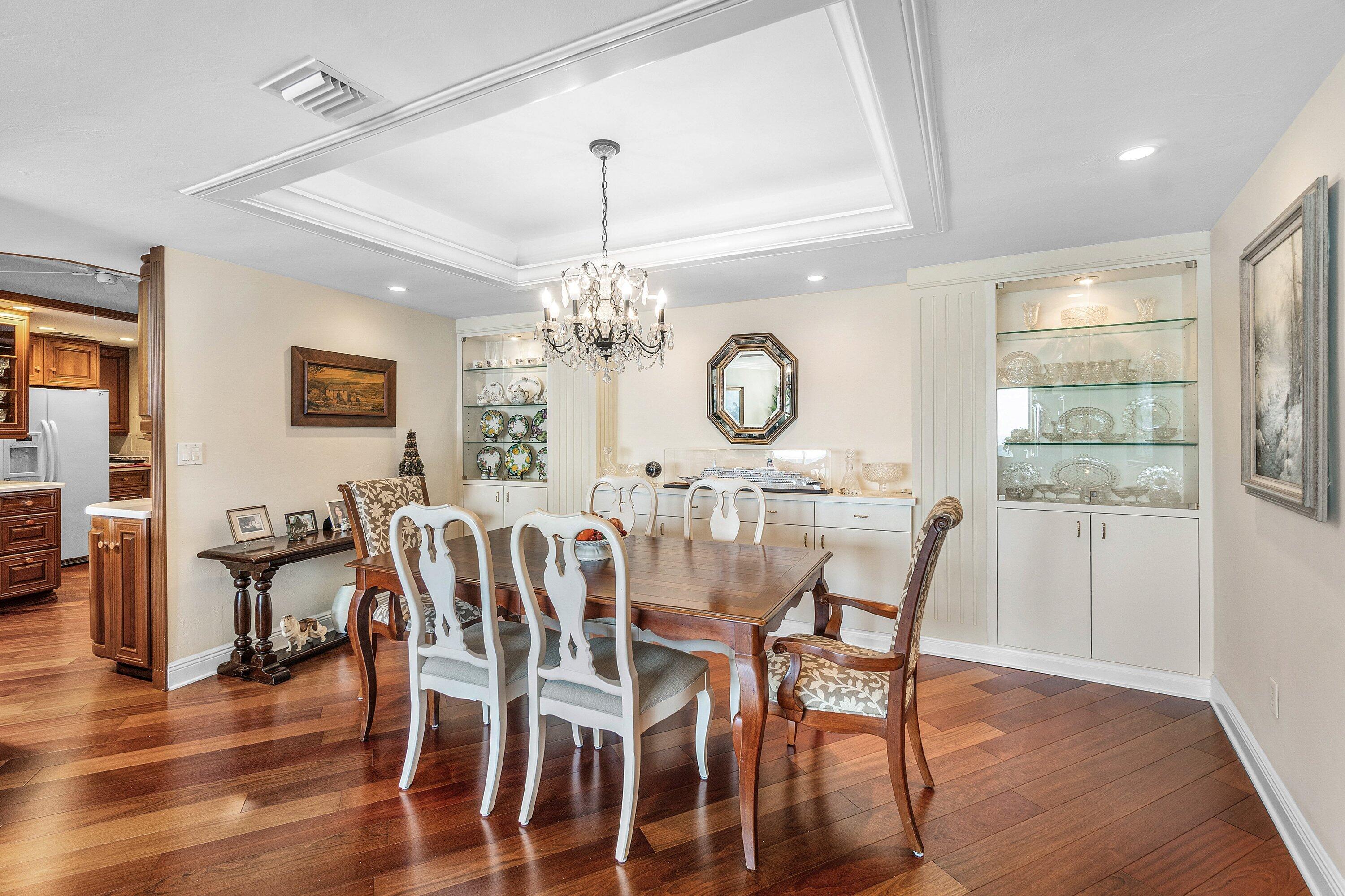700 South Ocean Boulevard, Unit 804 Boca Raton, FL 33432 - Photo 9 of 39 a view of a dining room with furniture a chandelier and wooden floor