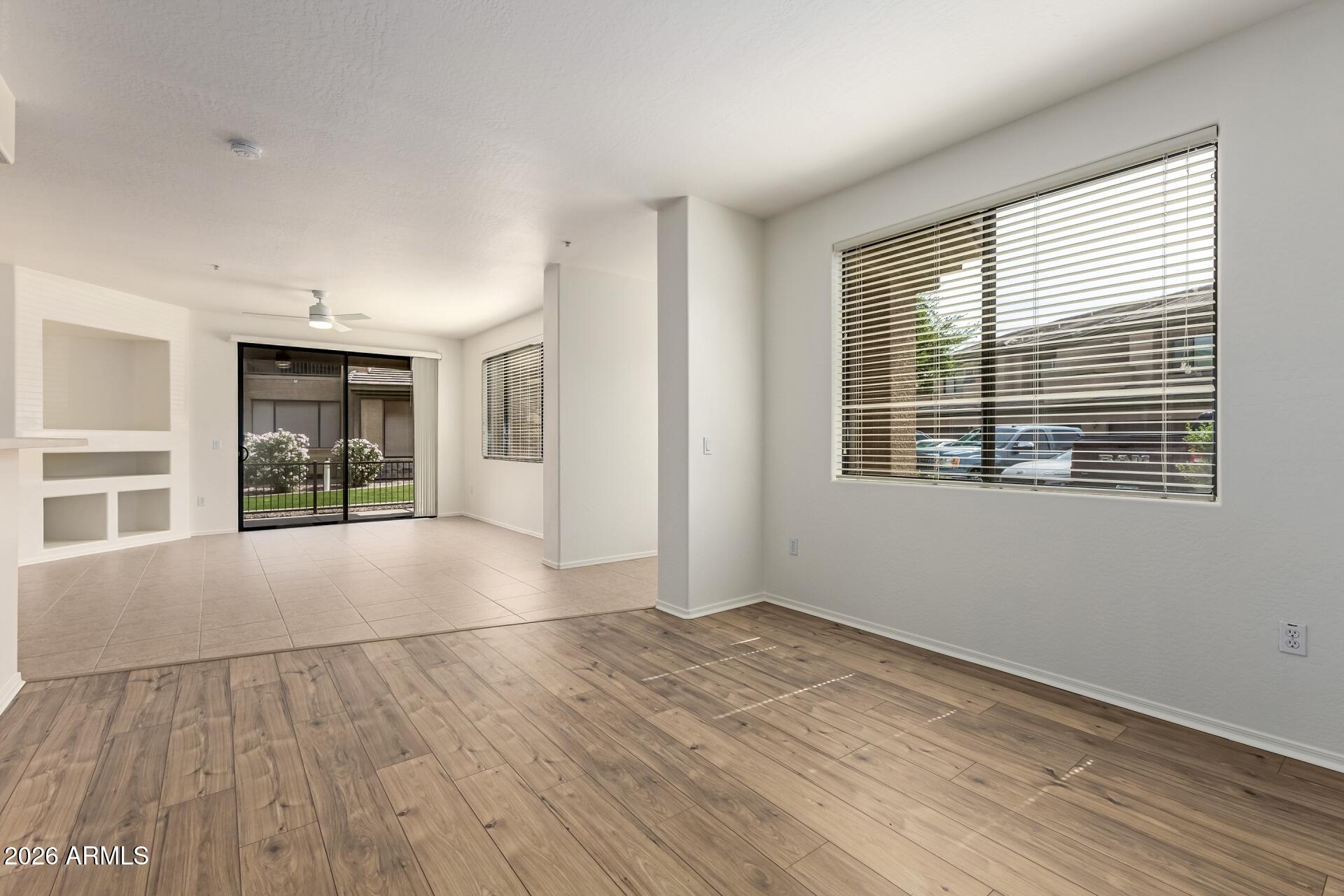705 West Queen Creek Road, Unit 1167 Chandler, AZ 85248 - Photo 7 of 31 a view of an empty room with wooden floor and a window