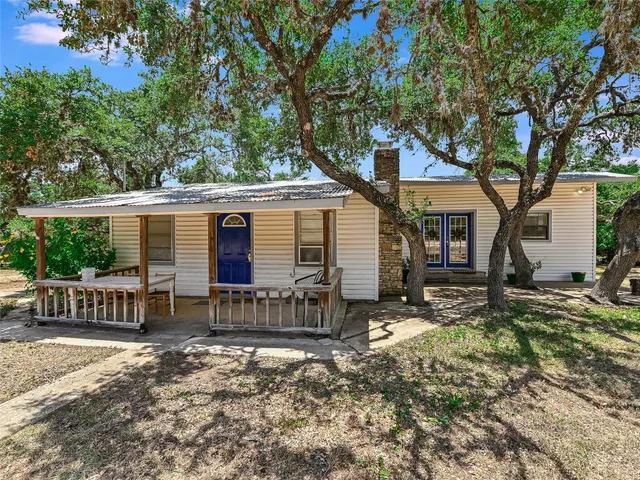 a backyard of a house with barbeque oven table and chairs