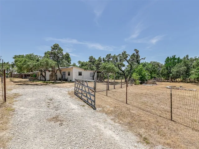 a view of a yard with wooden fence