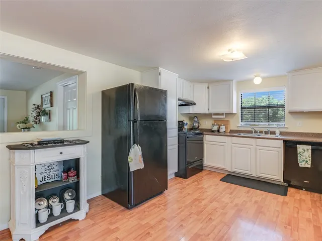 a kitchen with a refrigerator a stove and cabinets