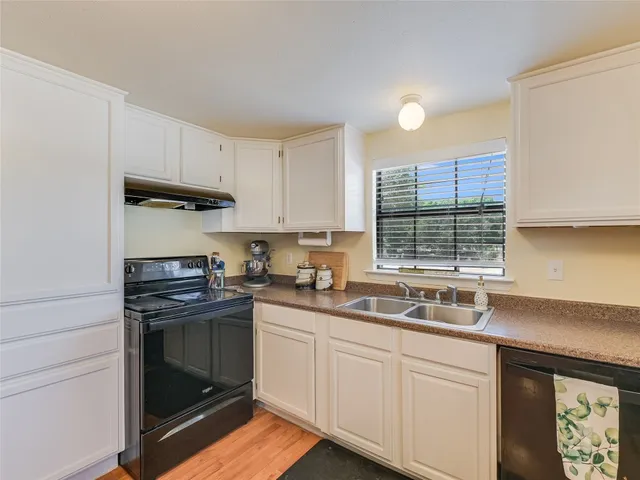 a kitchen with stainless steel appliances granite countertop a sink stove and cabinets