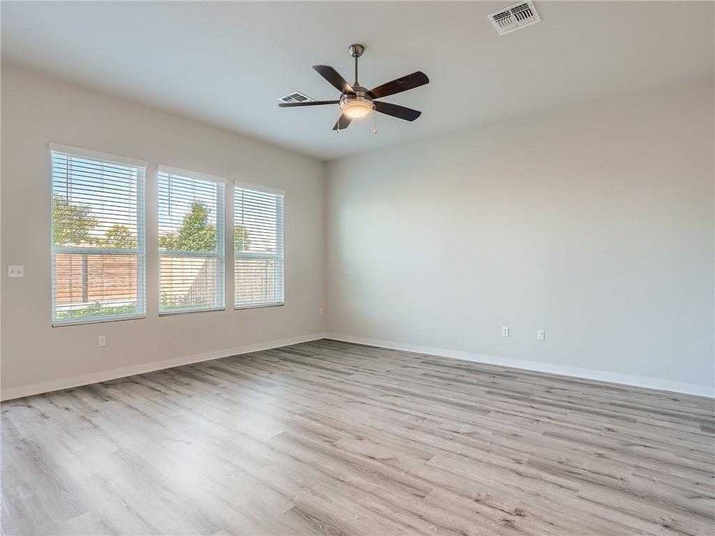 1309 Showbox Street, Unit 6 Pflugerville, TX 78660 - Photo 3 of 24 an empty room with wooden floor fan and windows