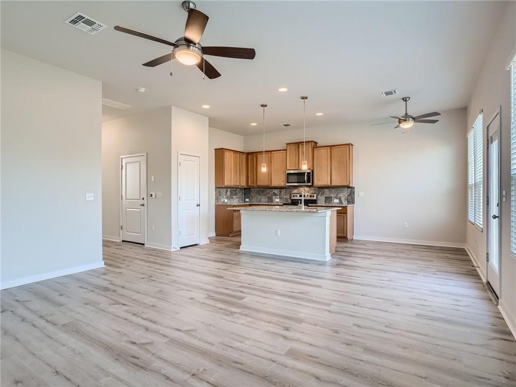 1309 Showbox Street, Unit 6 Pflugerville, TX 78660 - Photo 4 of 24 a view of kitchen with refrigerator microwave and stove
