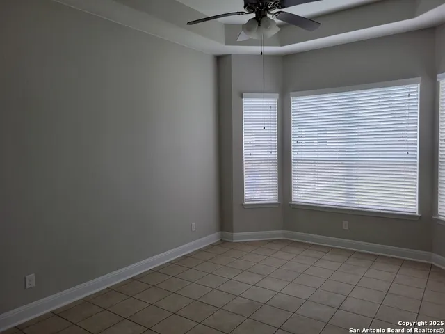 an empty room with a ceiling fan and window