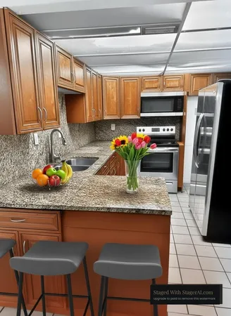 a kitchen with stainless steel appliances granite countertop a sink a stove and a wooden cabinets