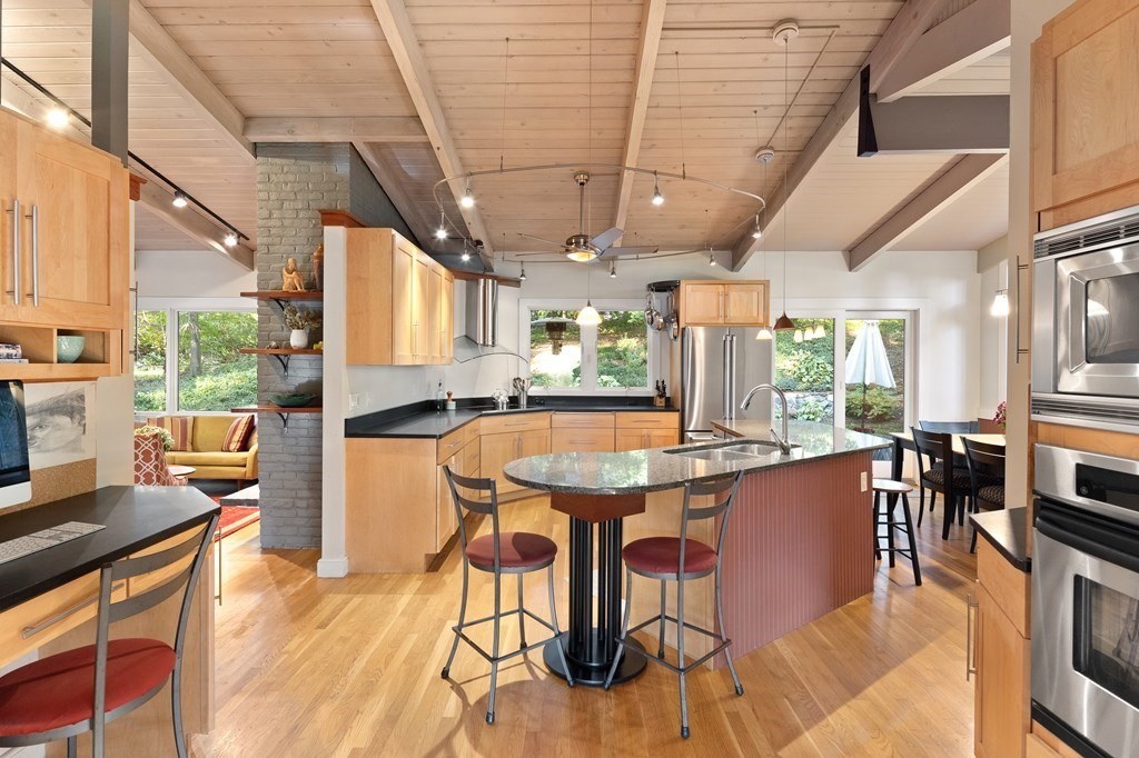 4 Lantern Lane Lexington, MA 02421 - Photo 10 of 29 a dining hall with stainless steel appliances granite countertop a stove a sink dishwasher and cabinets with wooden floor
