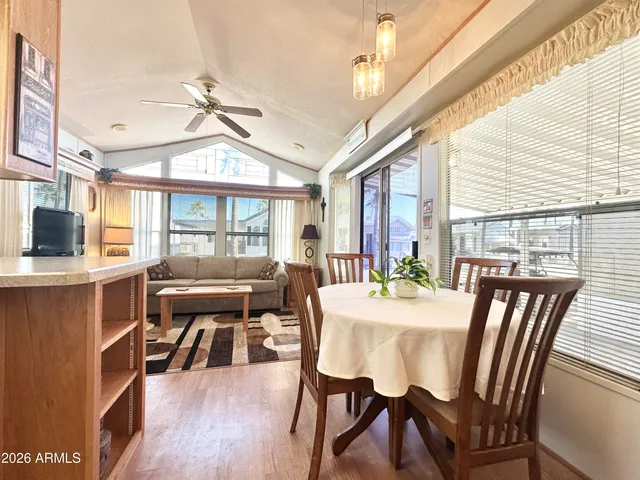 a dining room with furniture a chandelier and wooden floor