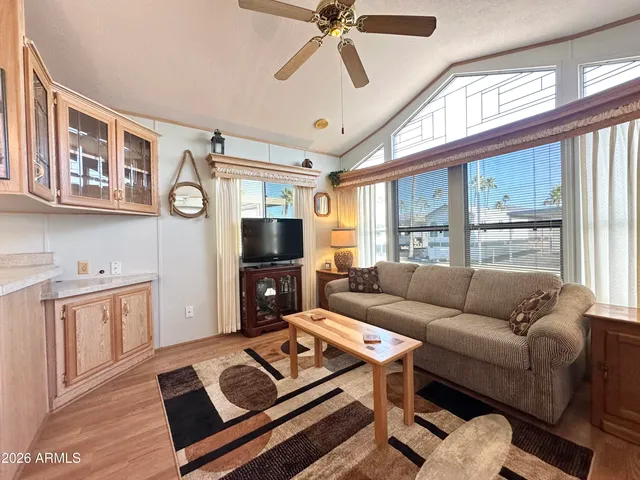a living room with furniture a flat screen tv and a window