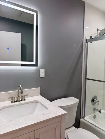 a bathroom with a sink a toilet and shower