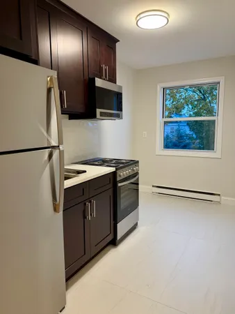a kitchen with stainless steel appliances granite countertop a refrigerator a stove a microwave with wooden floor and windows