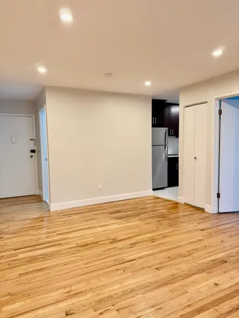 a view of empty room with wooden floor