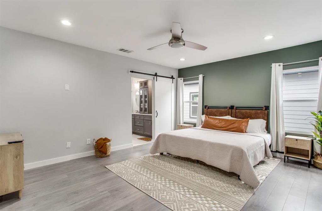 1606 West 12th Street Dallas, TX 75208 - Photo 7 of 20 Bedroom with a barn door, light wood finished floors, a ceiling fan, recessed lighting, and ensuite bath