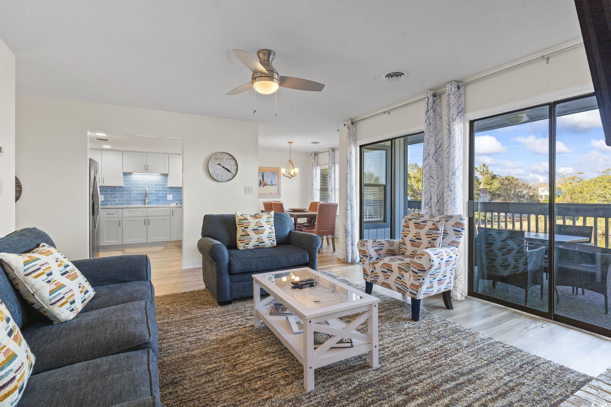 310 3rd Avenue North, Unit A2 Surfside Beach, SC 29575 - Photo 13 of 40 Living area with wood finished floors, ceiling fan, and a chandelier