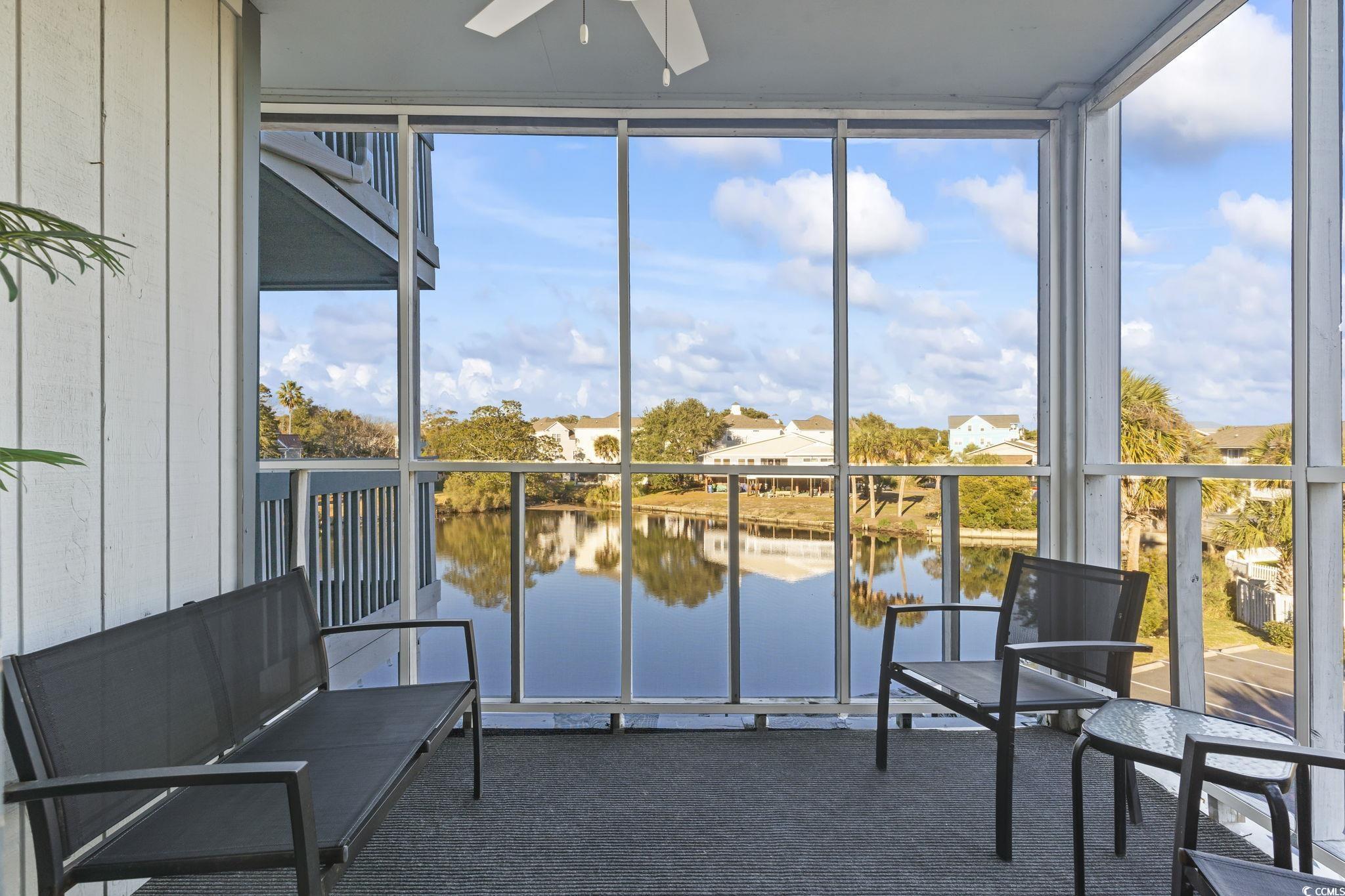 310 3rd Avenue North, Unit A2 Surfside Beach, SC 29575 - Photo 30 of 40 Sunroom with expansive windows, a water view, plenty of natural light, and carpet flooring