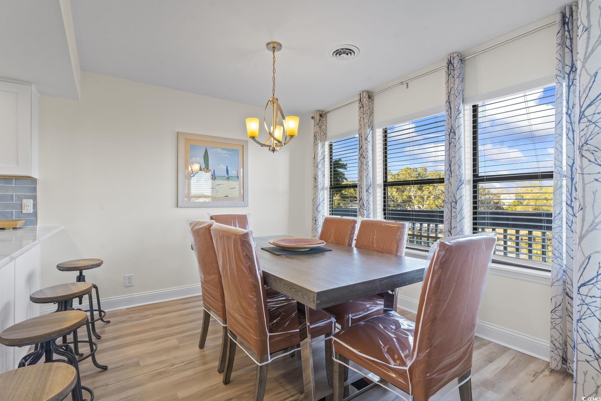310 3rd Avenue North, Unit A2 Surfside Beach, SC 29575 - Photo 9 of 40 Dining room with light wood-style floors and a chandelier