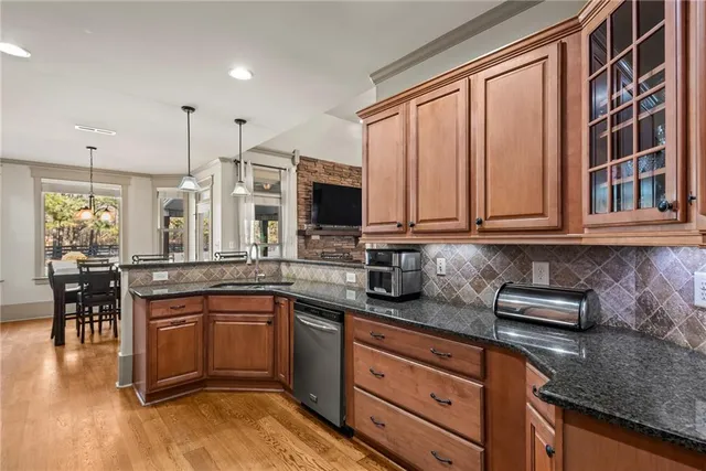 a kitchen with stainless steel appliances granite countertop a stove a sink and a microwave