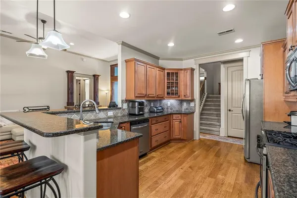 a kitchen with stainless steel appliances granite countertop a sink stove and refrigerator