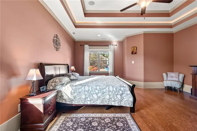 a bedroom with a bed a dresser and a flat screen tv