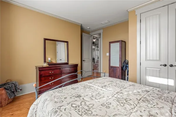 a bedroom with a bed and wooden floor
