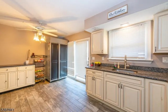 a kitchen with granite countertop a sink window and cabinets