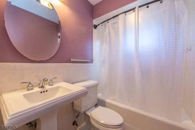 a bathroom with a sink a toilet and shower curtain