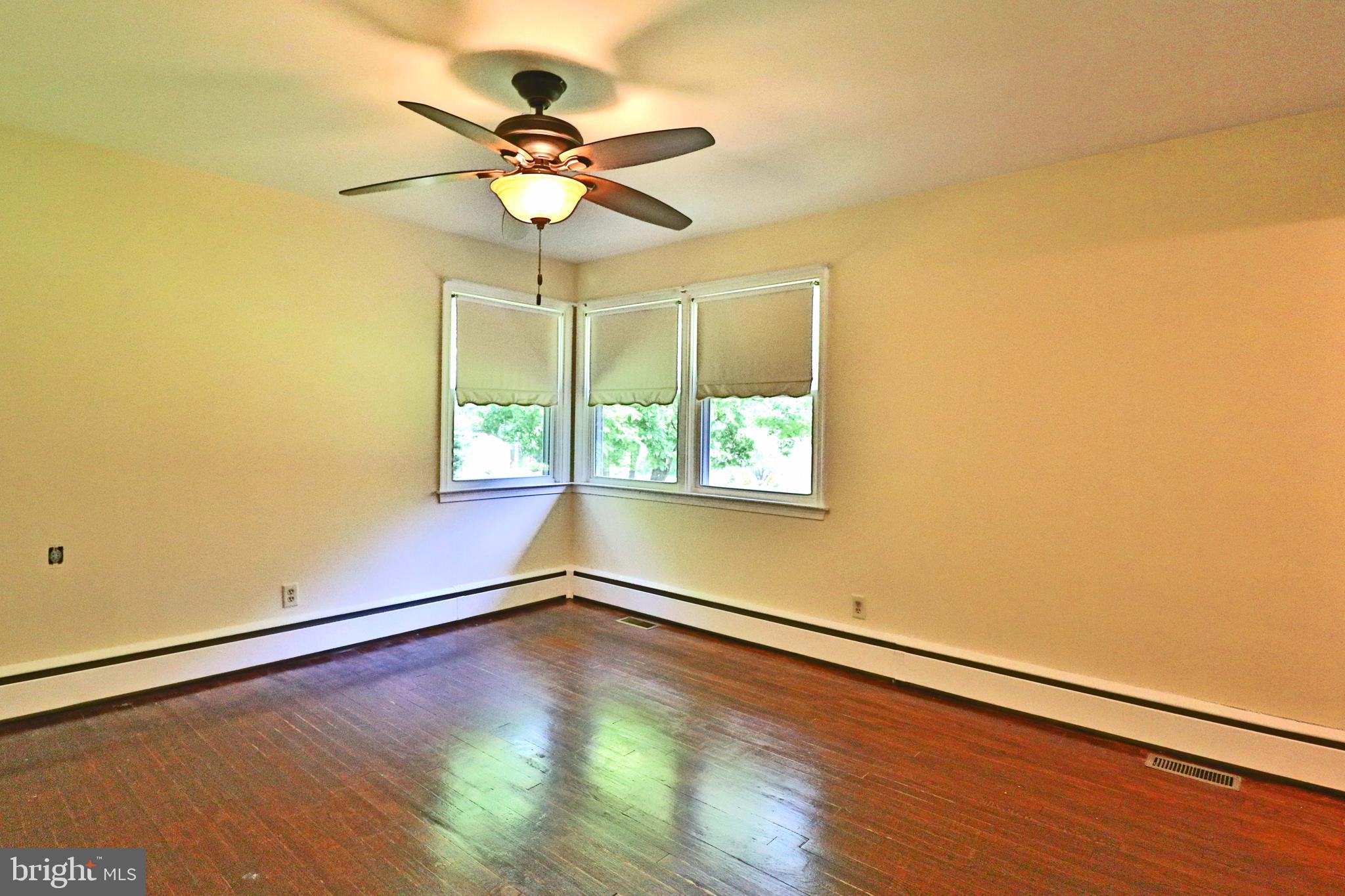 6708 Cherry Hill Road Baldwin, MD 21013 - Photo 12 of 44 an empty room with wooden floor fan and windows