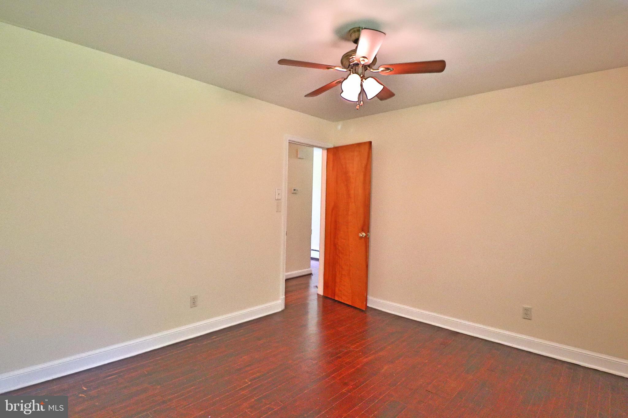 6708 Cherry Hill Road Baldwin, MD 21013 - Photo 19 of 44 an empty room with wooden floor fan and windows