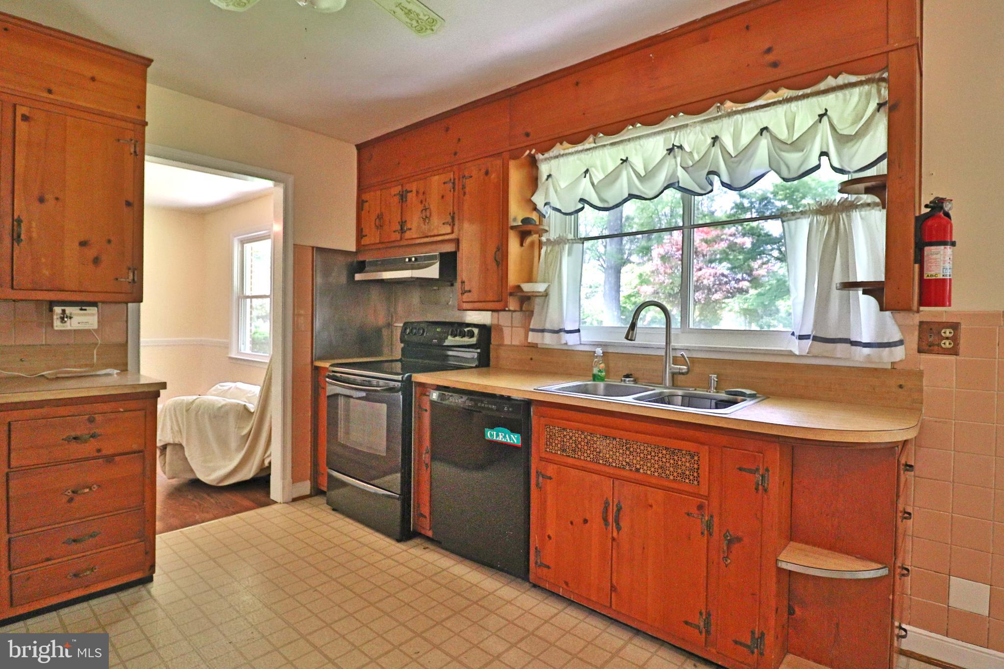 6708 Cherry Hill Road Baldwin, MD 21013 - Photo 10 of 44 a kitchen with granite countertop a sink stove and cabinets