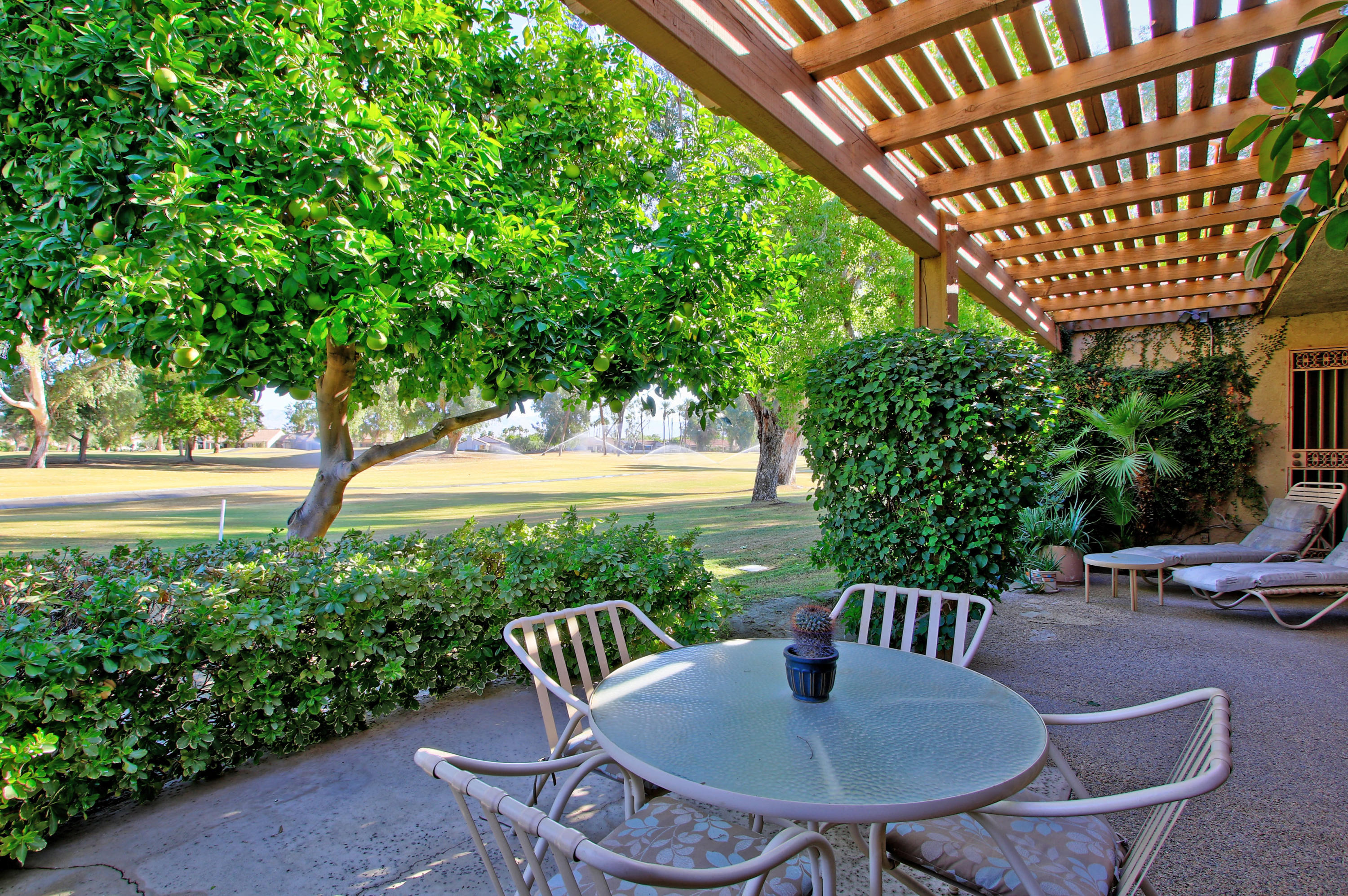 924 Inverness Drive Rancho Mirage, CA 92270 - Photo 34 of 44 a view of a patio that has a table and chairs with wooden floor and fence