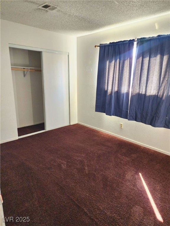 2308 Seco Adobe Circle North Las Vegas, NV 89030 - Photo 8 of 11 Unfurnished bedroom featuring carpet flooring, a textured wall, a textured ceiling, and a closet