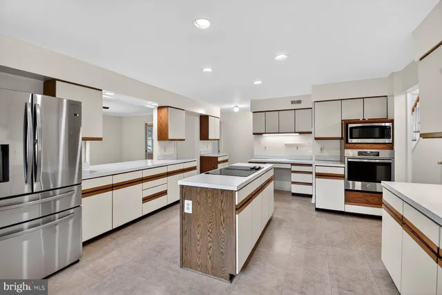 a kitchen with stainless steel appliances granite countertop a refrigerator a stove a sink and a refrigerator