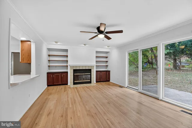 a view of a room with wooden floor and ceiling fan