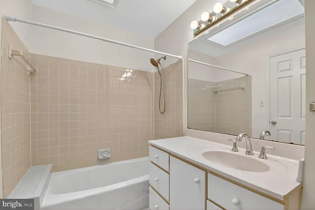 a bathroom with a granite countertop sink a mirror a shower and a bathtub