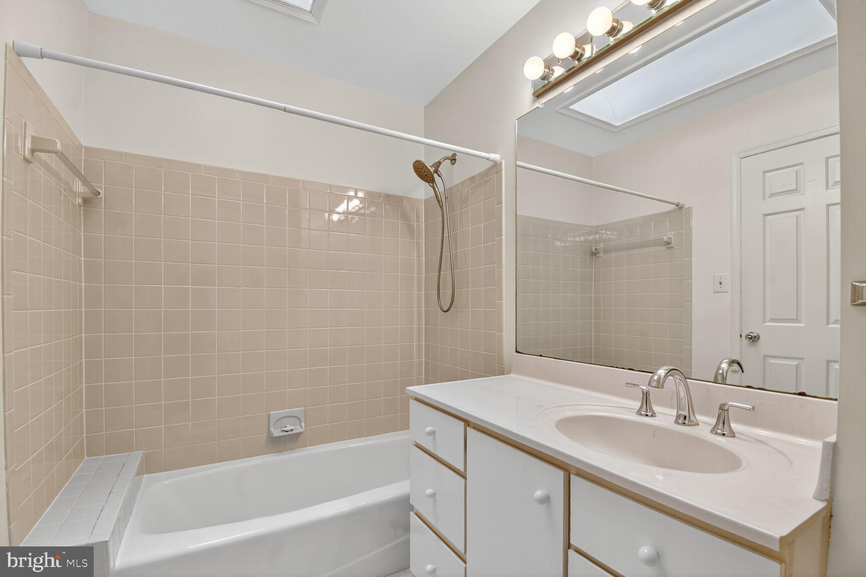11902 Bernard Drive Silver Spring, MD 20902 - Photo 32 of 47 a bathroom with a granite countertop sink a mirror a shower and a bathtub