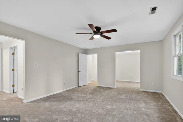 a view of a livingroom with a ceiling fan & window