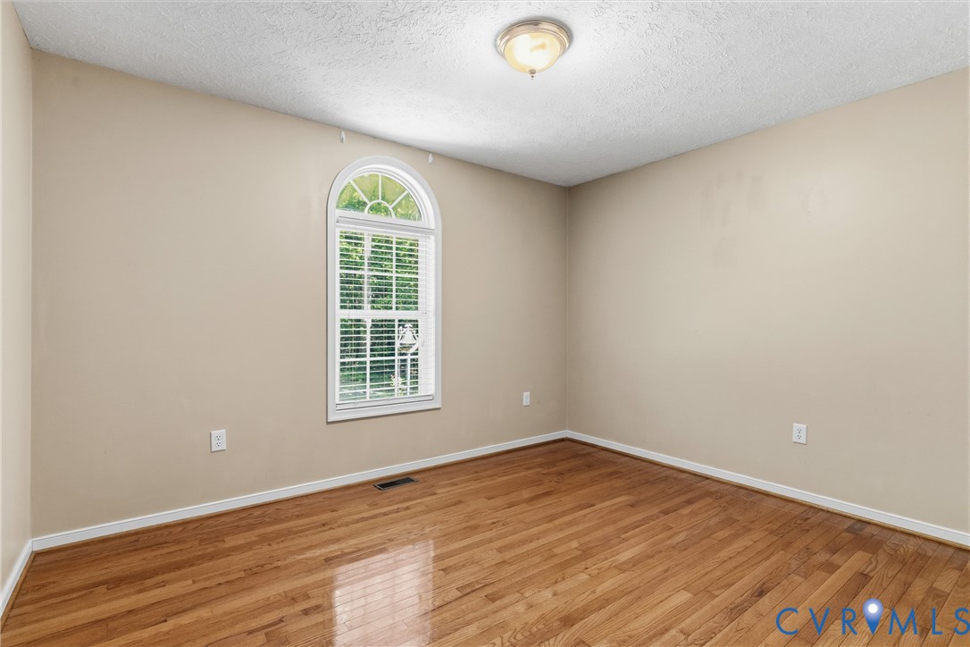 12654 Mt Olive Cohoke Road West Point, VA 23181 - Photo 21 of 31 an empty room with wooden floor and windows