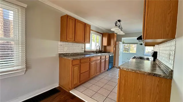 a kitchen with stainless steel appliances granite countertop a sink a stove and a refrigerator