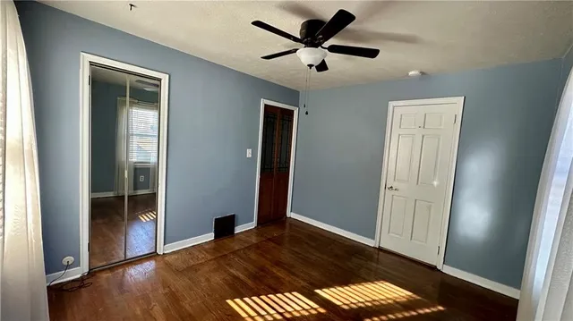 a view of a big room with wooden floor and windows