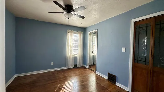 a view of a hallway with wooden floor and closet