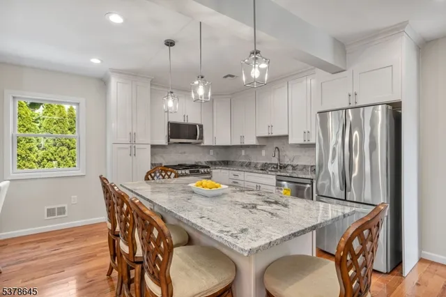 a kitchen with a table a refrigerator and a stove top oven