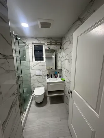 a bathroom with a sink a toilet and shower