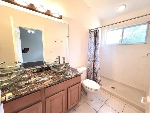 a bathroom with a granite countertop sink toilet and shower
