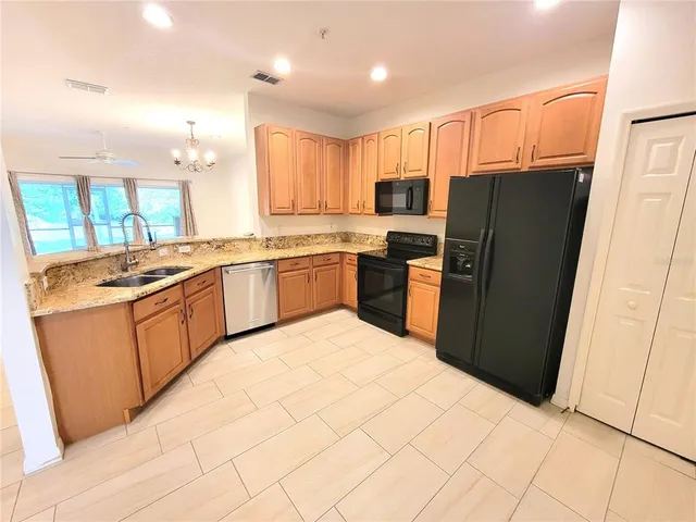 a kitchen with stainless steel appliances granite countertop a refrigerator stove and sink