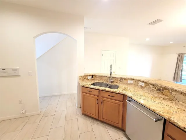 a view of a kitchen with granite countertop a sink and a stove