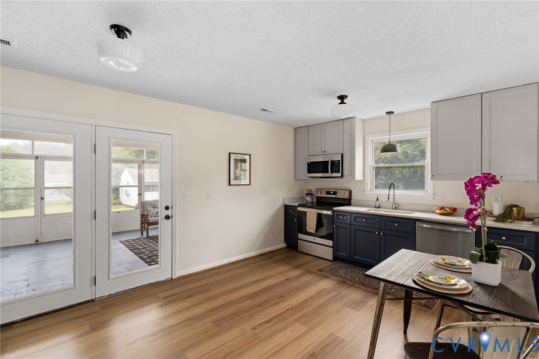 11345 Walton Lake Road Disputanta, VA 23842 - Photo 11 of 37 a large kitchen with cabinets wooden floor and stainless steel appliances