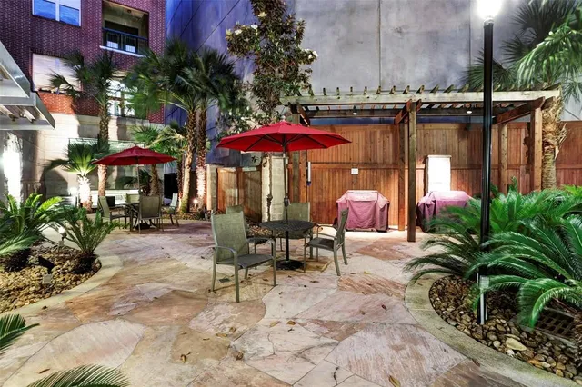 a view of a house with a large window and potted plants
