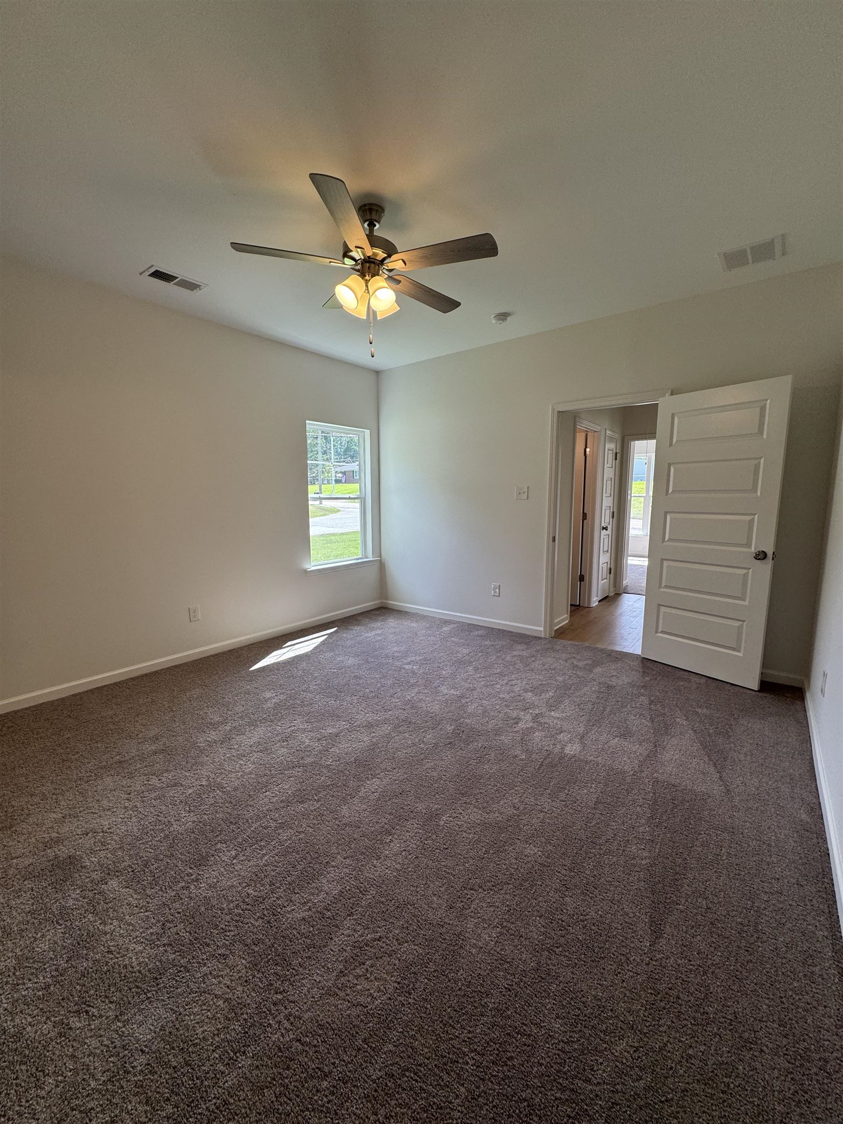 12370 South Main Street Somerville, TN 38068 - Photo 11 of 26 Neutral wall tones, ceiling fan with integrated lighting, window for natural illumination, carpeted flooring, and a paneled door